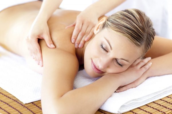 Relaxed smiling woman receiving a back massage in a spa